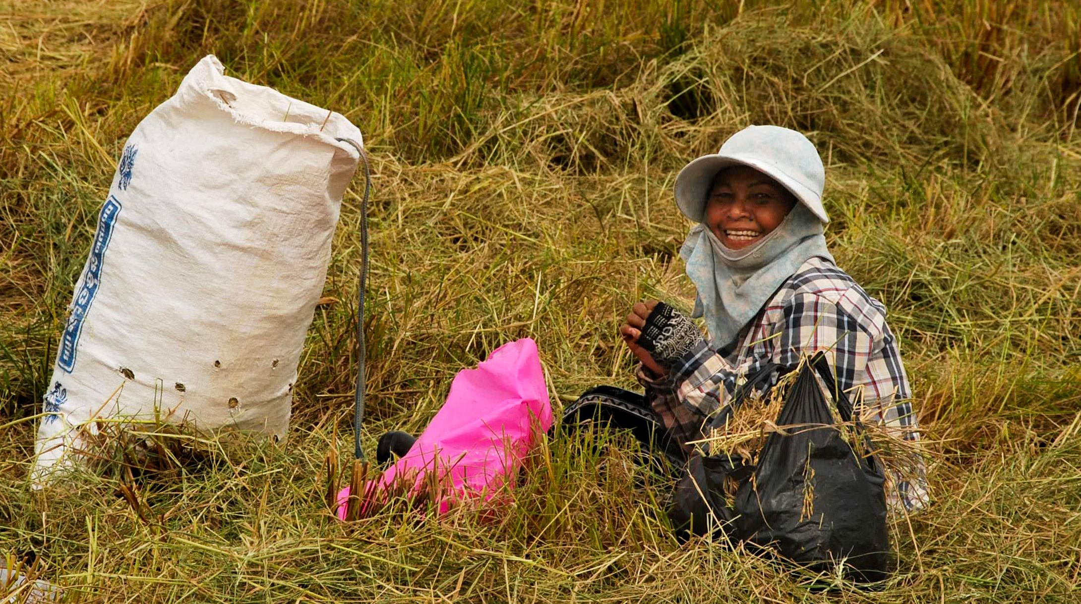 A smiling rice farmer greeting cyclists on a countryside road near Kampot