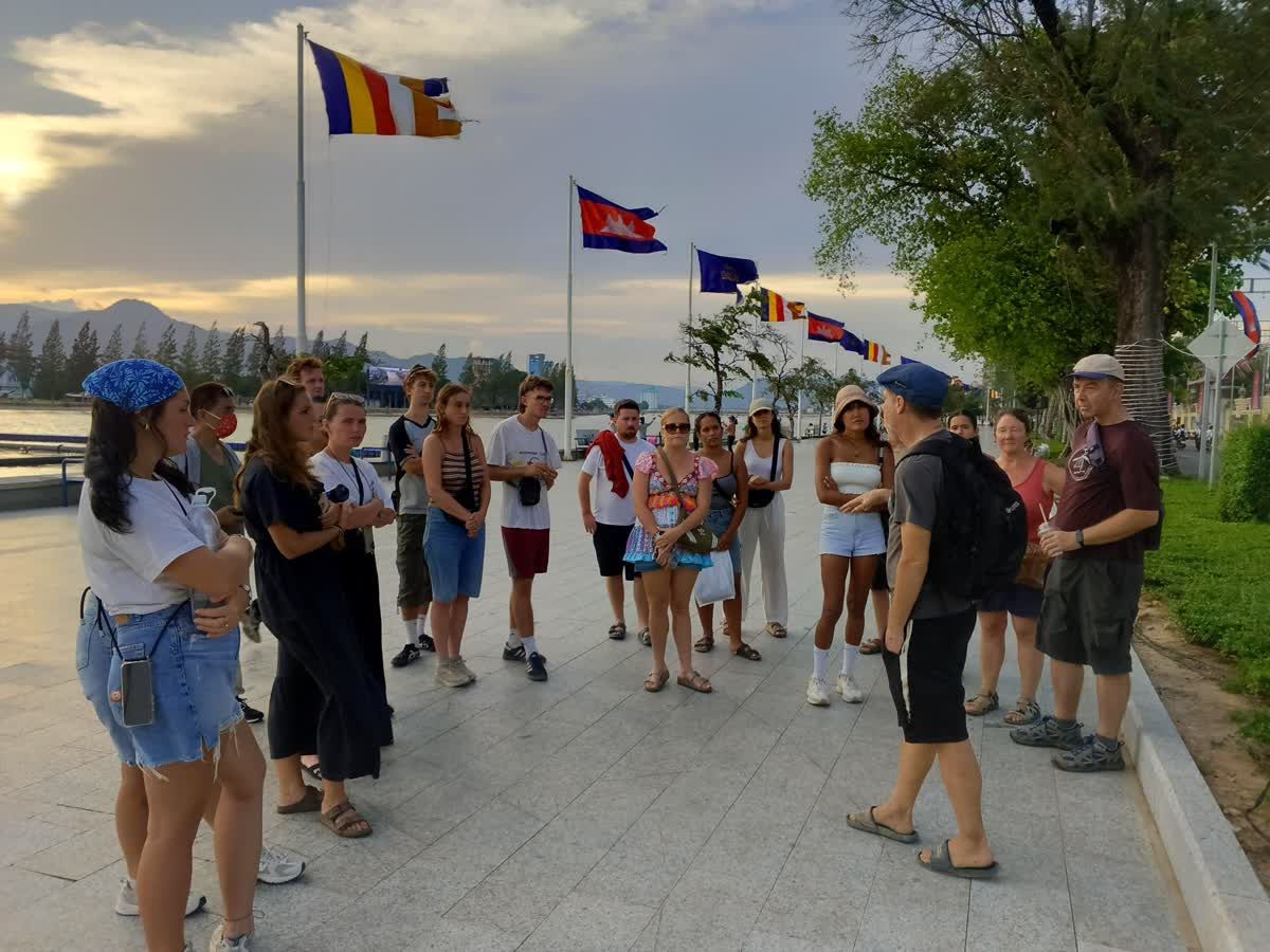 Travellers gathered on the Kampot riverside promenade at sunset