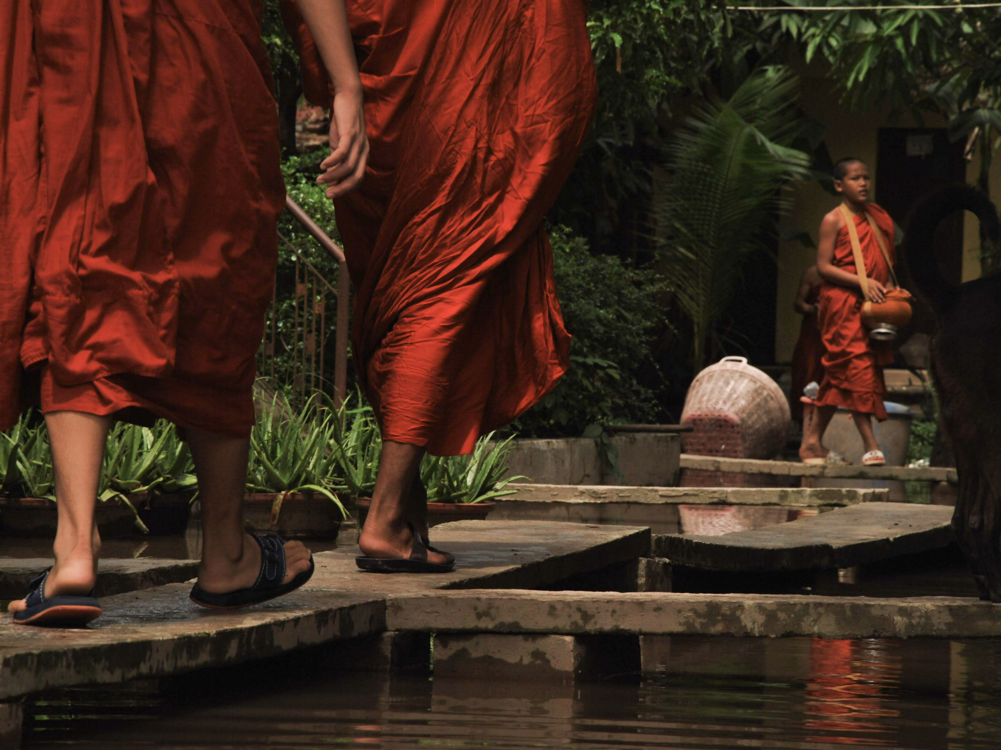 Buddhist monks walking in saffron robes near a pagoda